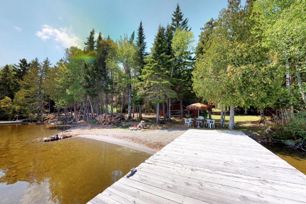 un puente de madera sobre un cuerpo de agua en Moosehead Memories, en Rockwood
