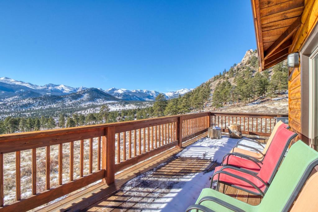 a deck with chairs and a view of the mountains at High Pines Cabin in Estes Park