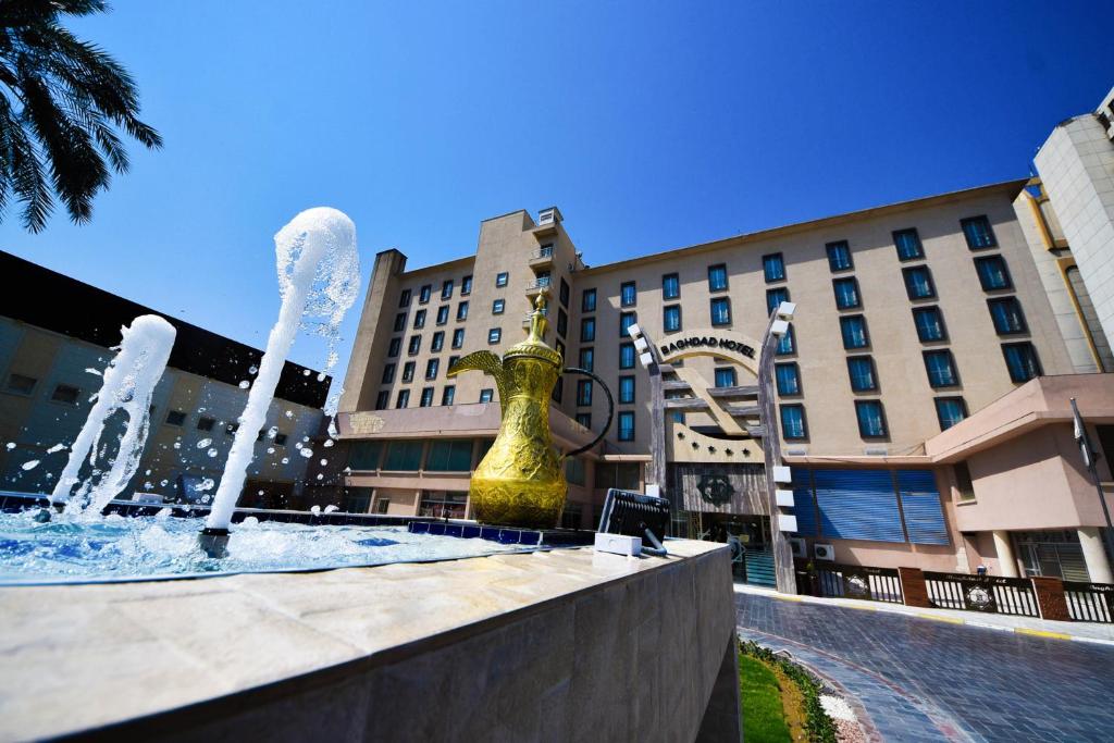 uma fonte de água em frente a um edifício em فندق بغداد Baghdad International Hotel em Bagdade