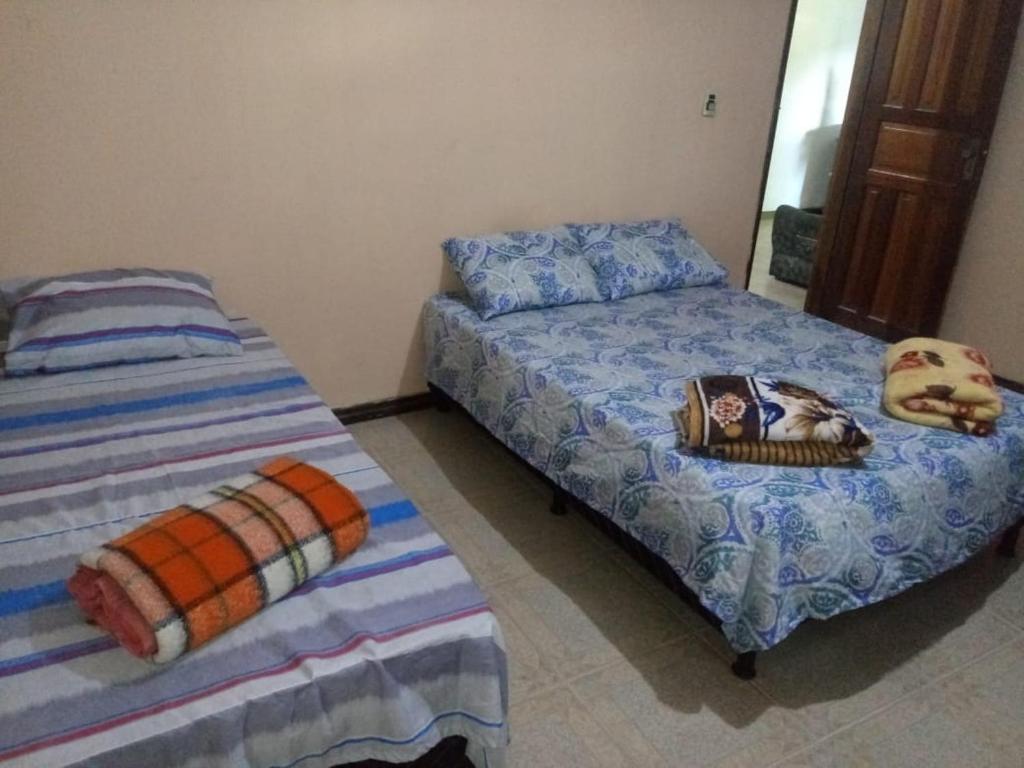 a bedroom with two beds and a picture on the bed at Sitio Santo Antonio HOSTEL in Ilhéus