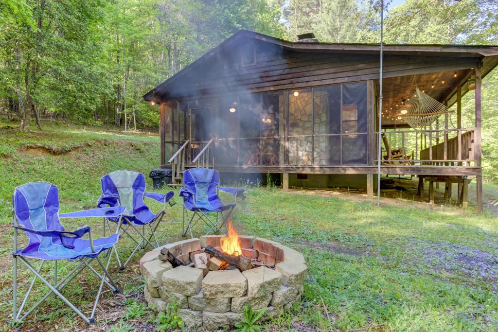 a group of chairs around a fire pit in front of a cabin at Moss Creek Cabin in Morganton
