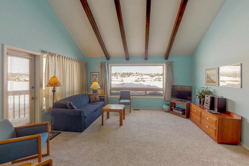 a living room with a blue couch and a tv at Aspenwood 4229-30 in Pagosa Springs