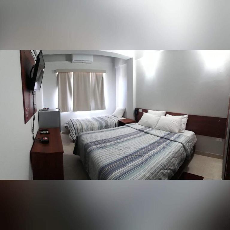 Postel nebo postele na pokoji v ubytování Madame Lynch Hotel Asuncion