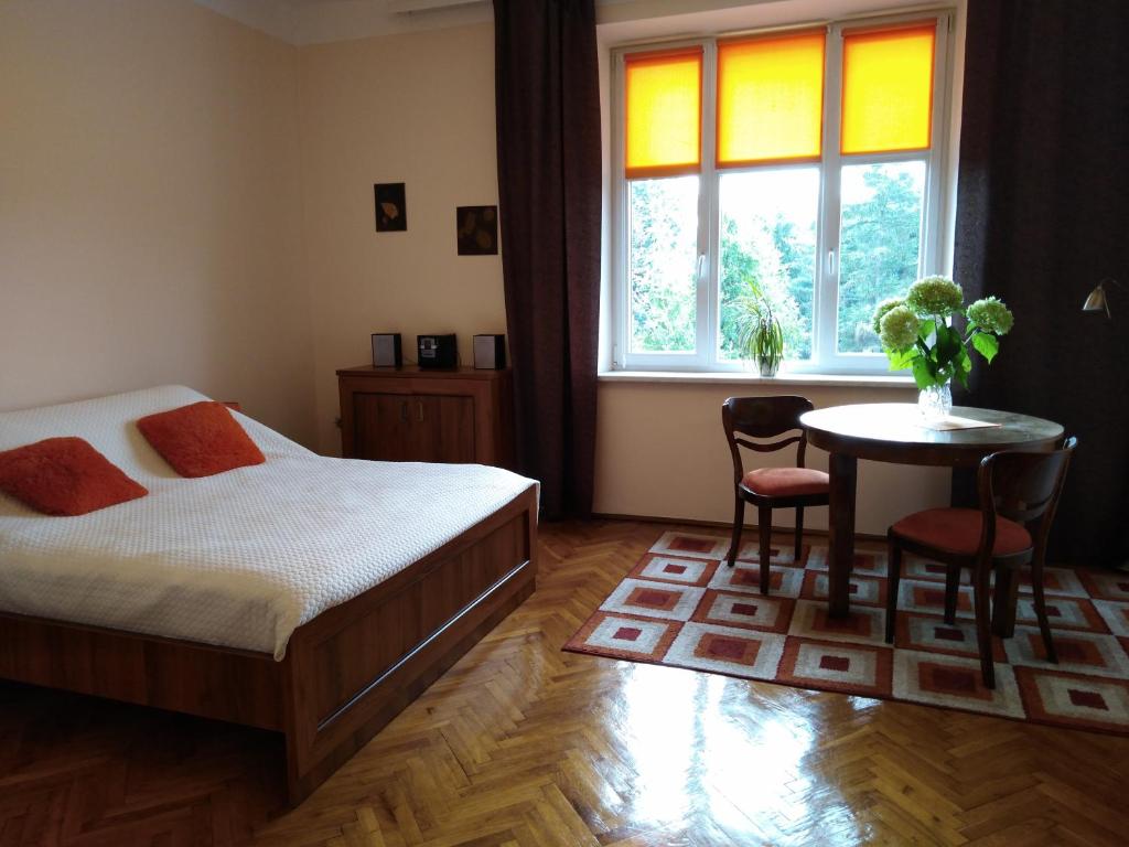 sypialnia z łóżkiem, stołem i oknem w obiekcie Studio Krakowski Styl w Krakowie
