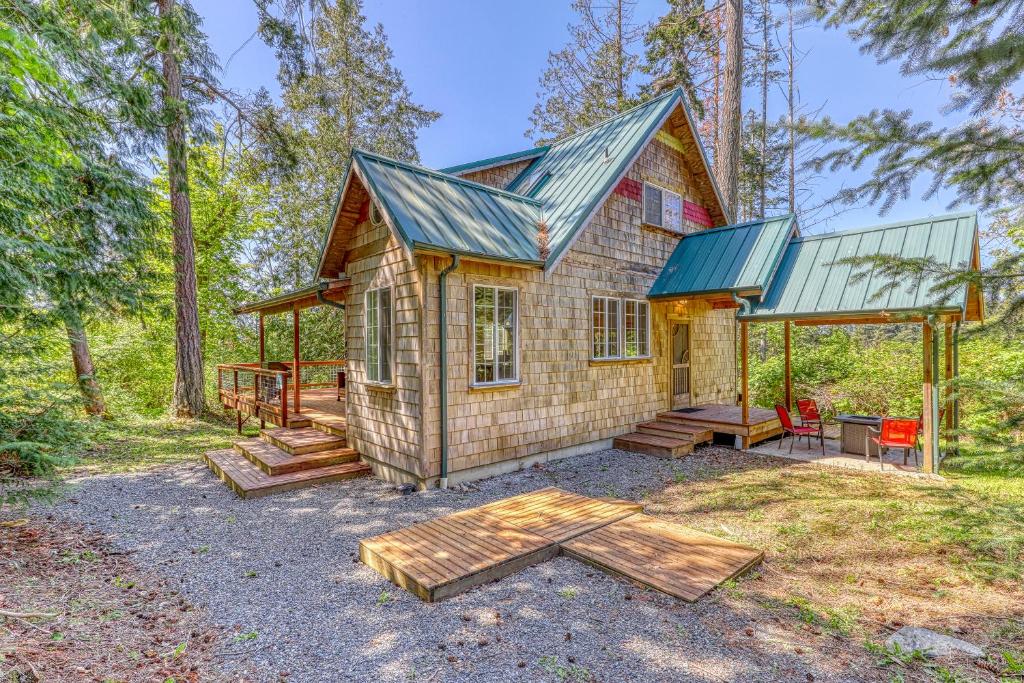 ein winziges Haus im Wald mit einer Veranda in der Unterkunft Camano Writer's Cottage in Indian Beach