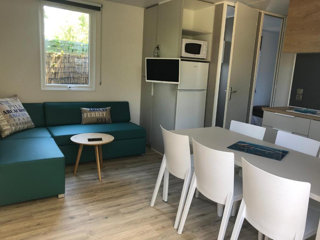 a living room with a couch and a table at Mobil home PREMIUM 35m2 3 chambres 6 personnes in Arès