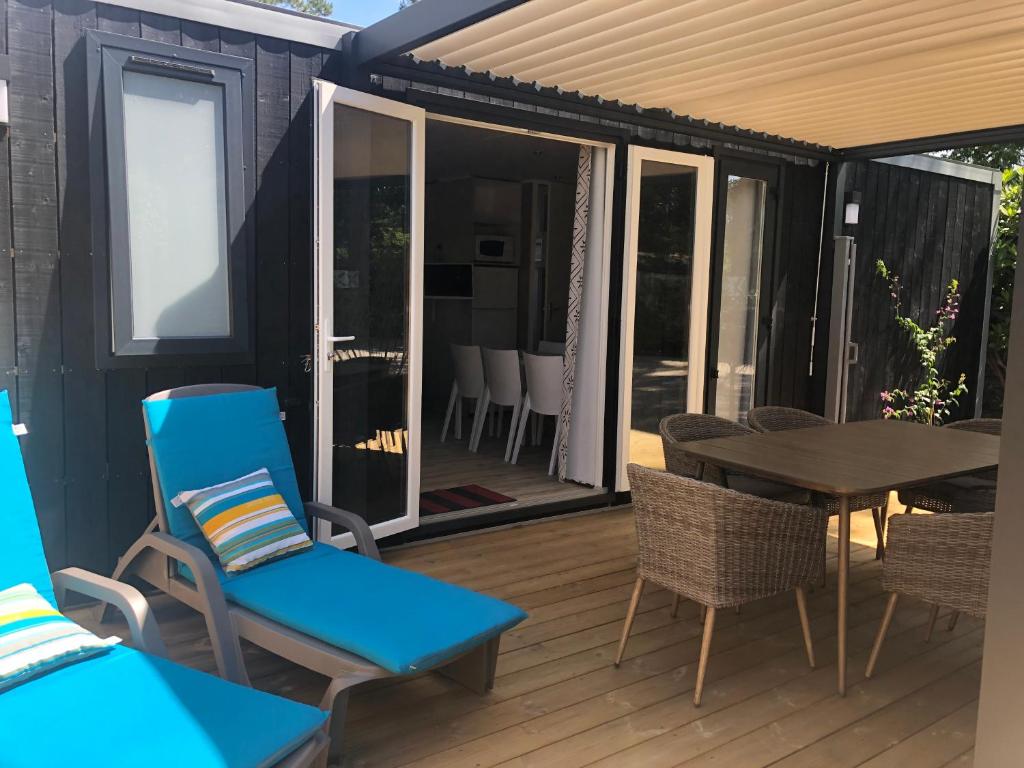 a screened in deck with a table and chairs at Mobil home PREMIUM 35m2 3 chambres 6 personnes in Arès