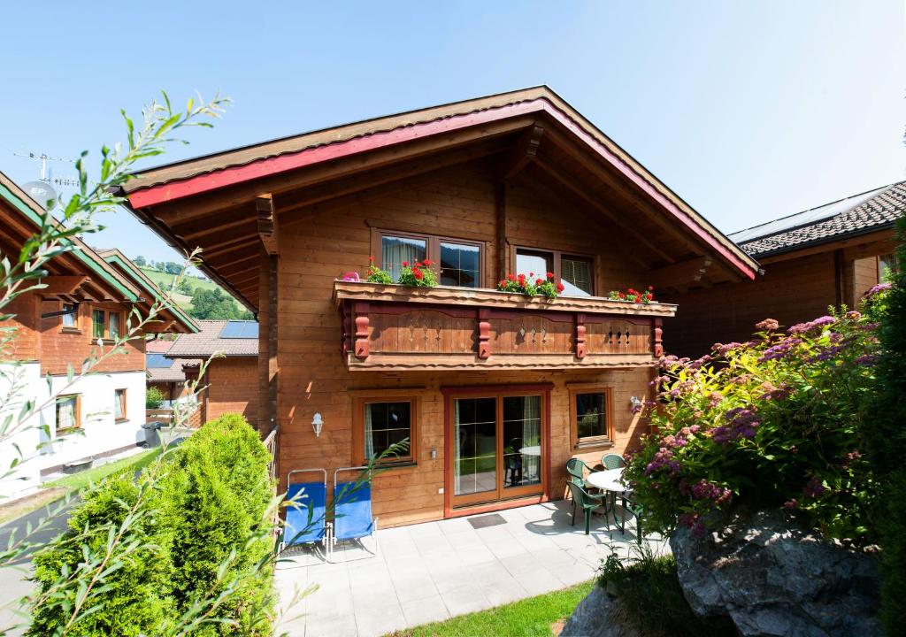 uma casa com uma varanda com flores em Feriendorf Wildschönau em Niederau