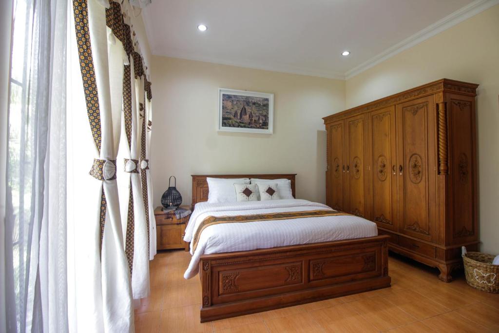 um quarto com uma cama e um armário de madeira em Nginap at Joy House em Sleman