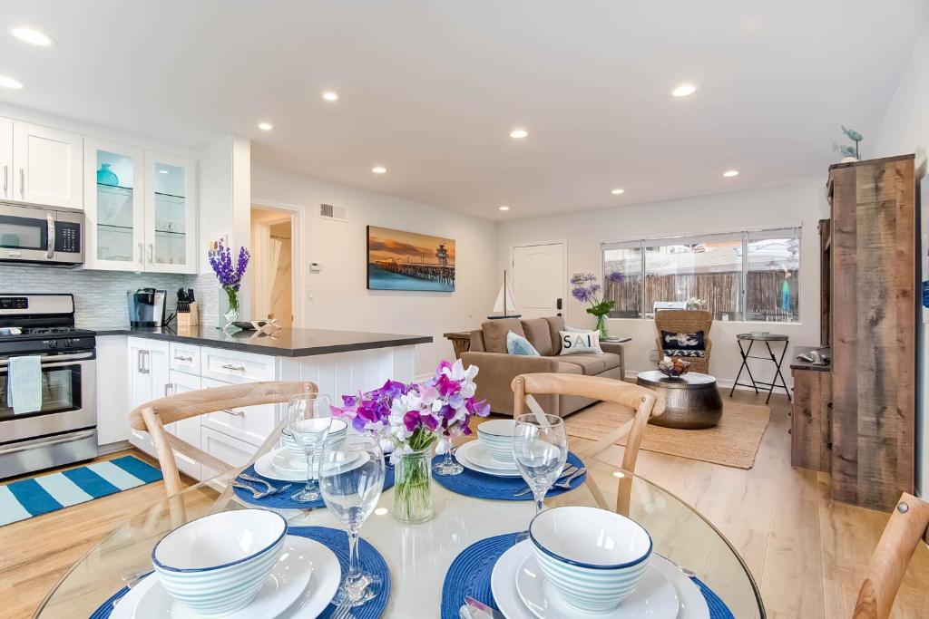 a kitchen and living room with a glass table and chairs at Hideaway Unit C in San Clemente