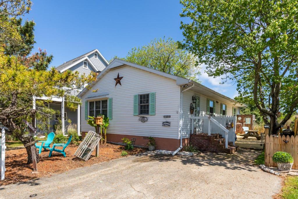 a white house with a fence and a yard at The Seashell Cottage in Ocean City