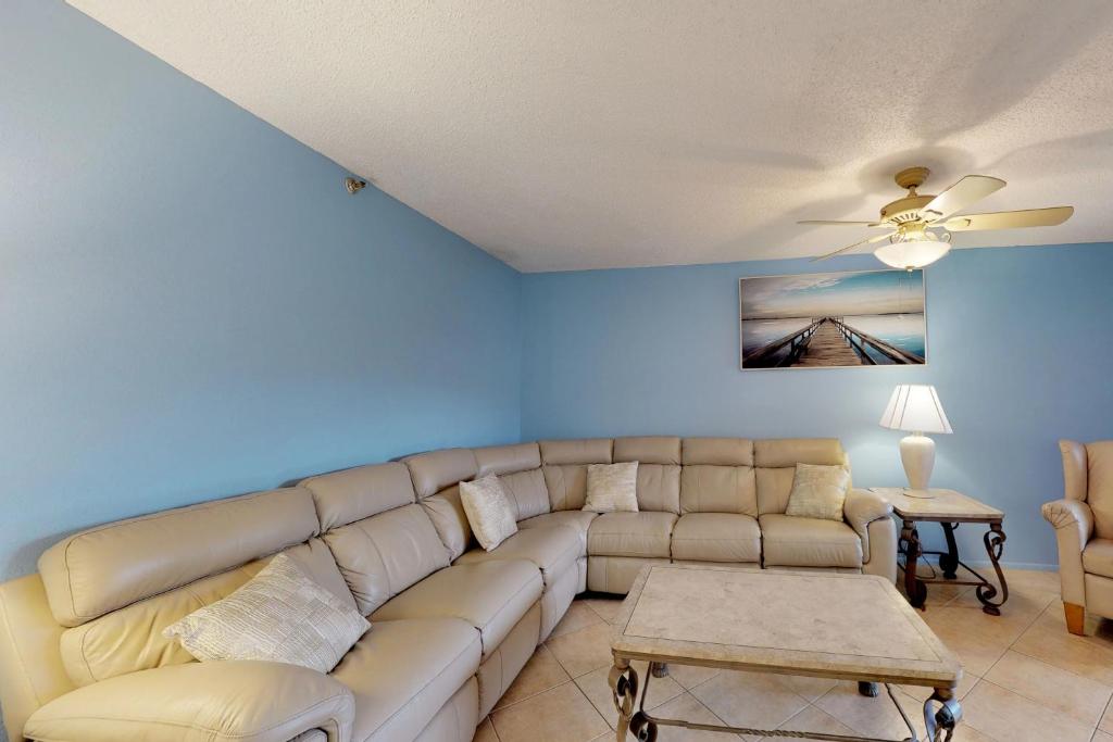 a living room with a couch and a ceiling fan at Reef Club 105 in Clearwater Beach