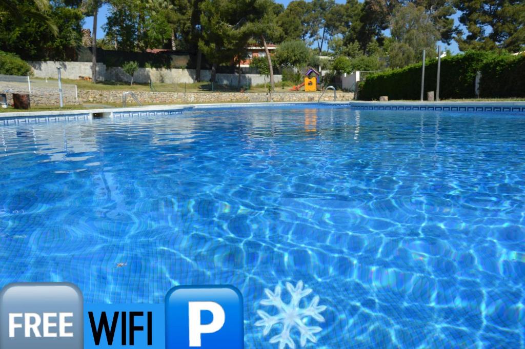 una piscina azul con un cartel que diga wifi gratis en Pool, Beach, Golf & Hard Rock in Salou, en Salou