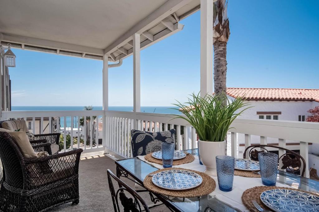 a patio with tables and chairs on a balcony with the ocean at Monterey A in San Clemente