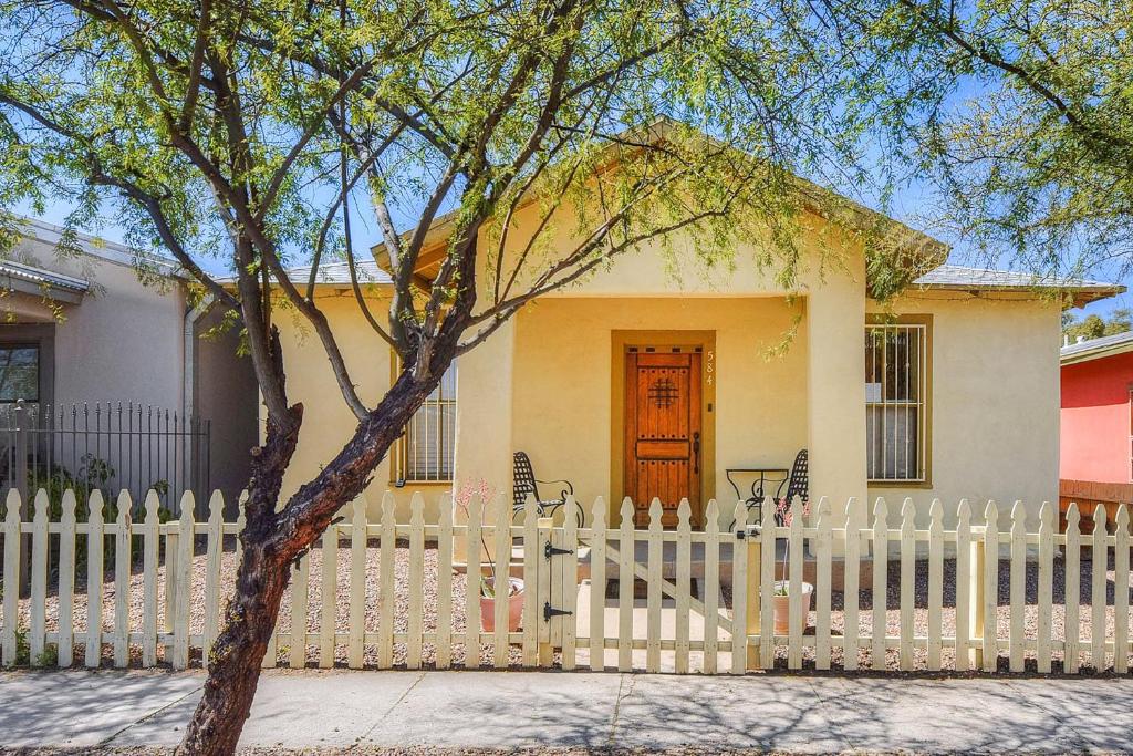 a white fence in front of a house with a wooden door at Barrio Casita 2 in Tucson