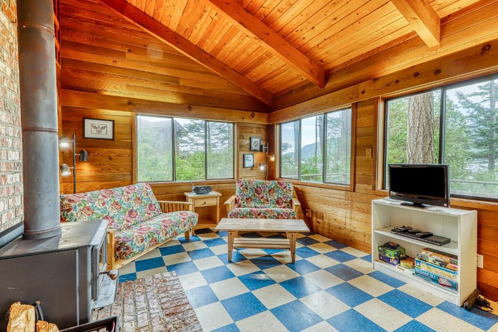 a living room with a fireplace and a tv at Lohman Lookout in Eastsound