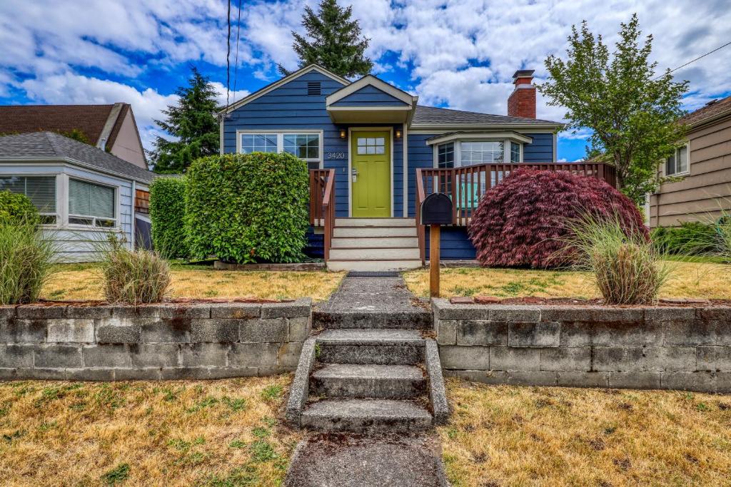 a blue house with a green door and stairs at Alki Beach House in Seattle