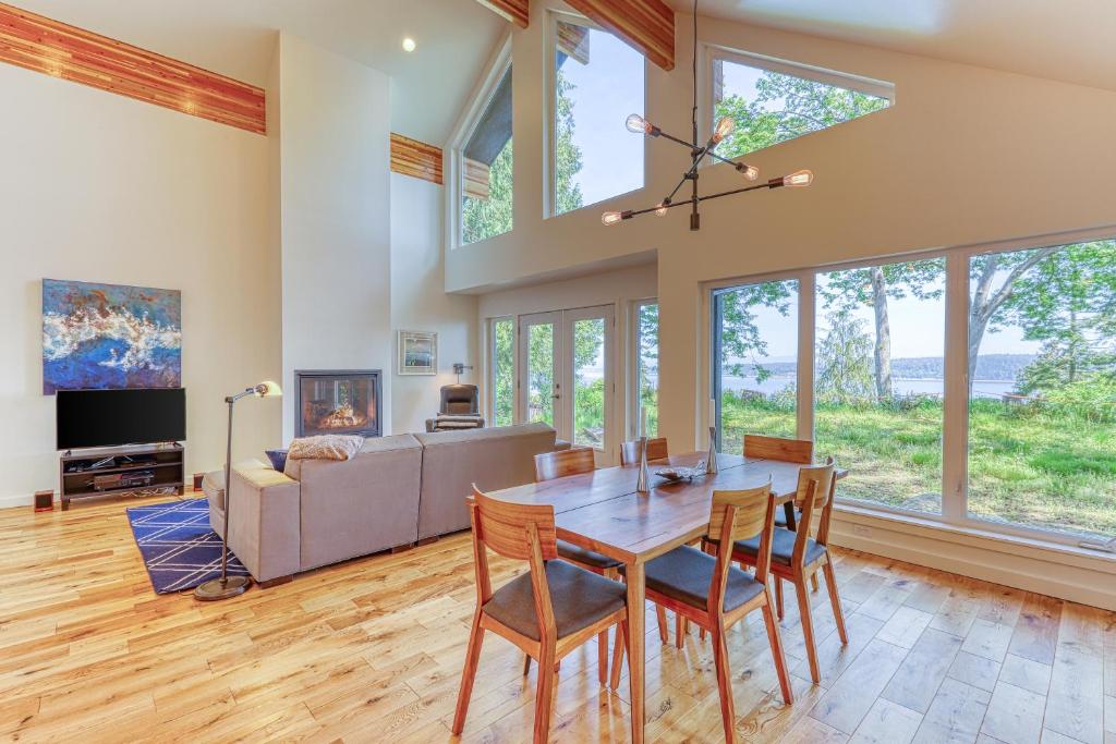 a dining room with a table and chairs and a couch at Cascade Mountains View in Sunny Shore Acres