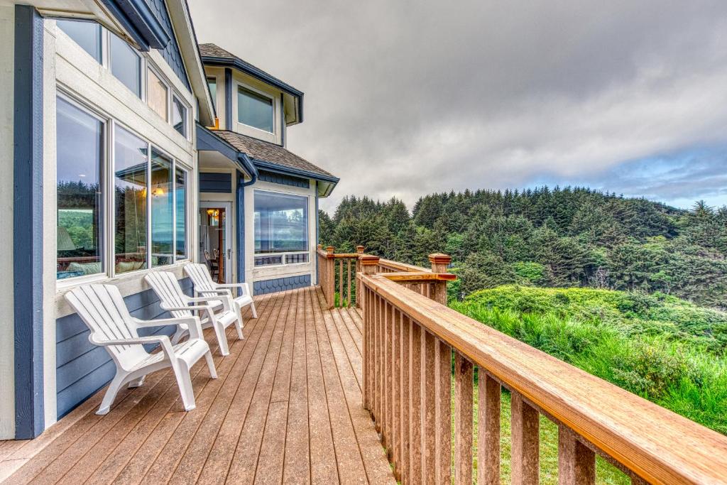 a wooden deck with two chairs on a house at Agate Beach Haven - 4 Bed 4 Bath Vacation home in Bandon in Bandon