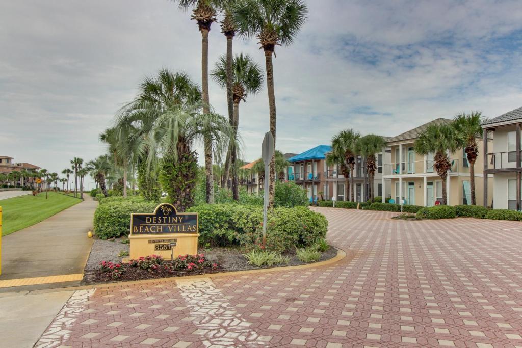 un panneau au milieu d'une allée avec des palmiers dans l'établissement Destiny Beach Villa #6A, à Destin