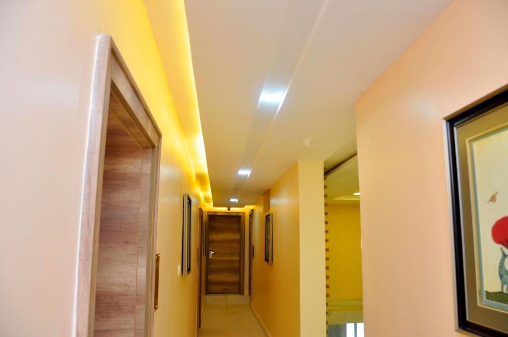 a hallway in a hospital with yellow ceilings at Lit Suites in Abuja