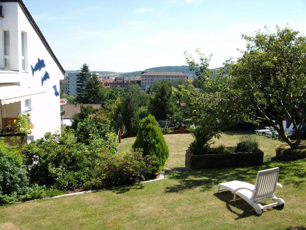 a white chair sitting in the grass next to a house at Haus Delphin in Bad Wildungen