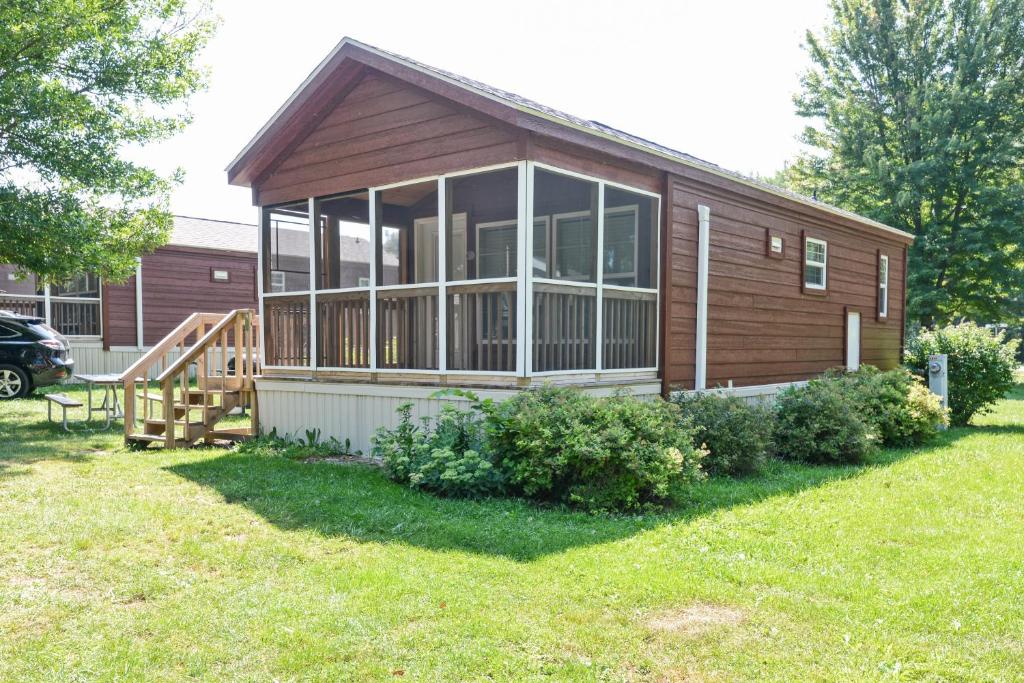 a small house with a large window and a yard at O'Connell's RV Campground Deluxe Park Model 38 in Inlet