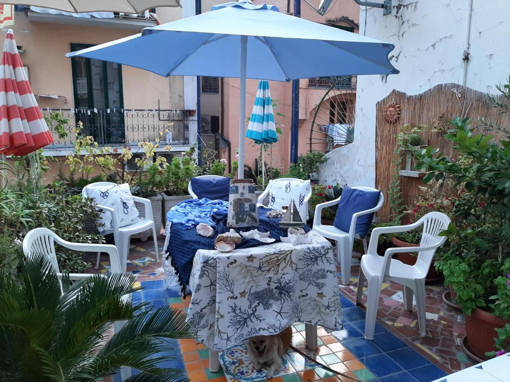 a table and chairs with a blue umbrella on a patio at La Casa di Rita in Cetara