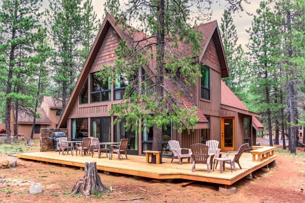 une maison avec des chaises et des tables sur une terrasse dans l'établissement 8 Cedar Lane, à Sunriver