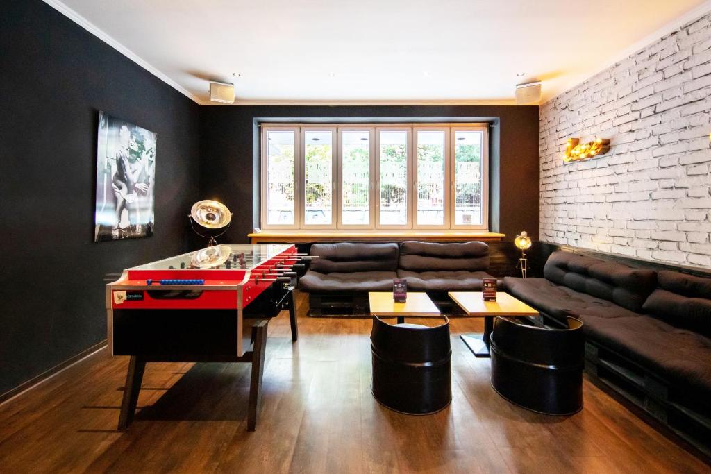 uma sala de estar com uma mesa de pingue-pongue e um sofá em Sonata City Hotel em Colónia