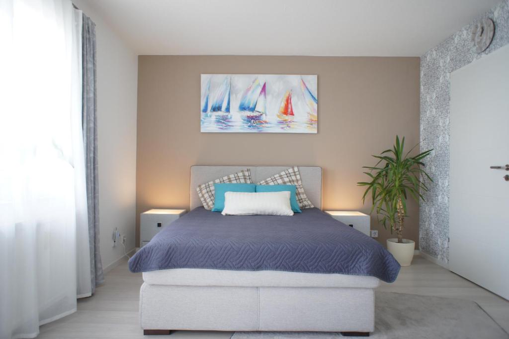 ein Schlafzimmer mit einem Bett und Segelbooten an der Wand in der Unterkunft Ferienwohnung Lörrach Alice in Lörrach