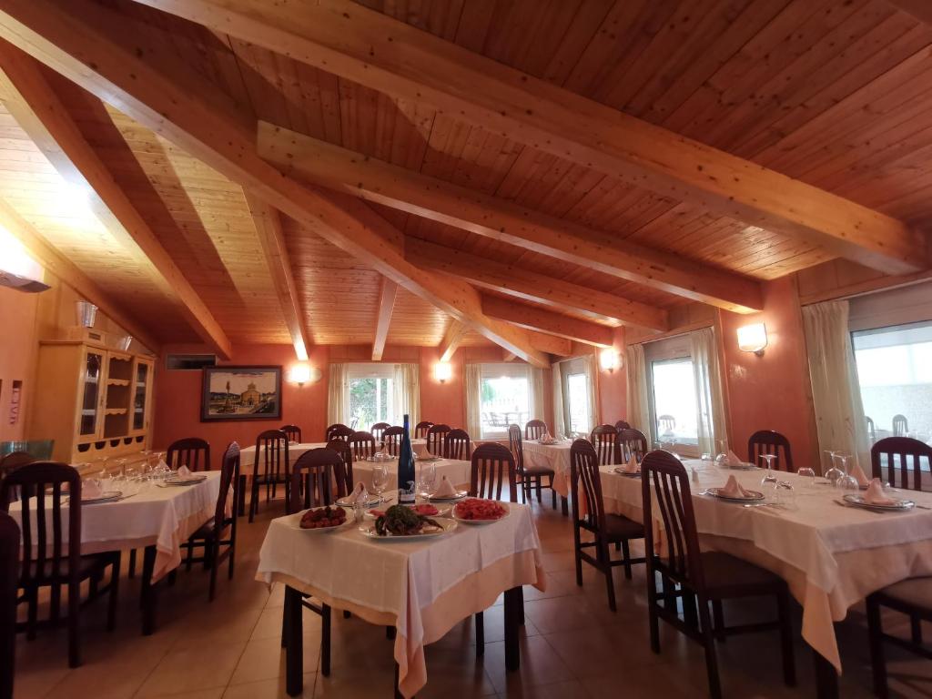 a dining room with tables and chairs and wooden ceilings at Doade in Hio
