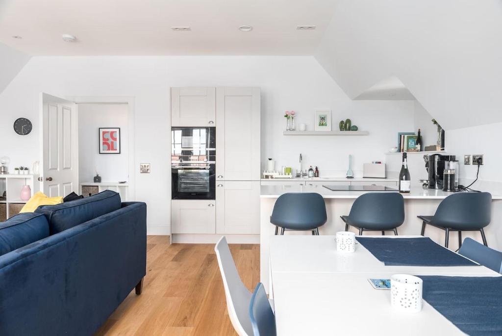 a living room with a blue couch and a kitchen at Luxurious living in Gullane in Edinburgh