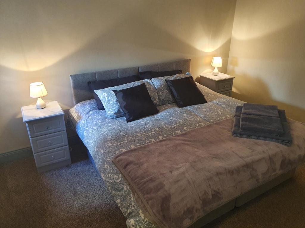 ein Schlafzimmer mit einem Bett mit zwei Nachttischen und zwei Lampen in der Unterkunft Junior Suite Town Centre in Dungarvan