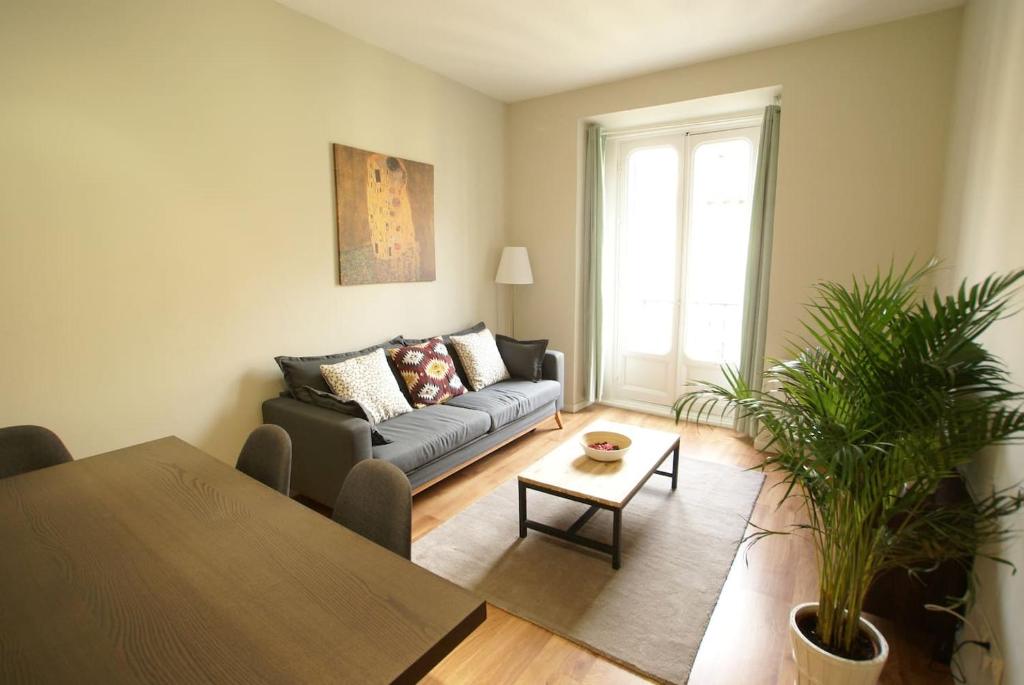 Luxury Apartment in Historic Center في مدريد: غرفة معيشة مع أريكة وطاولة