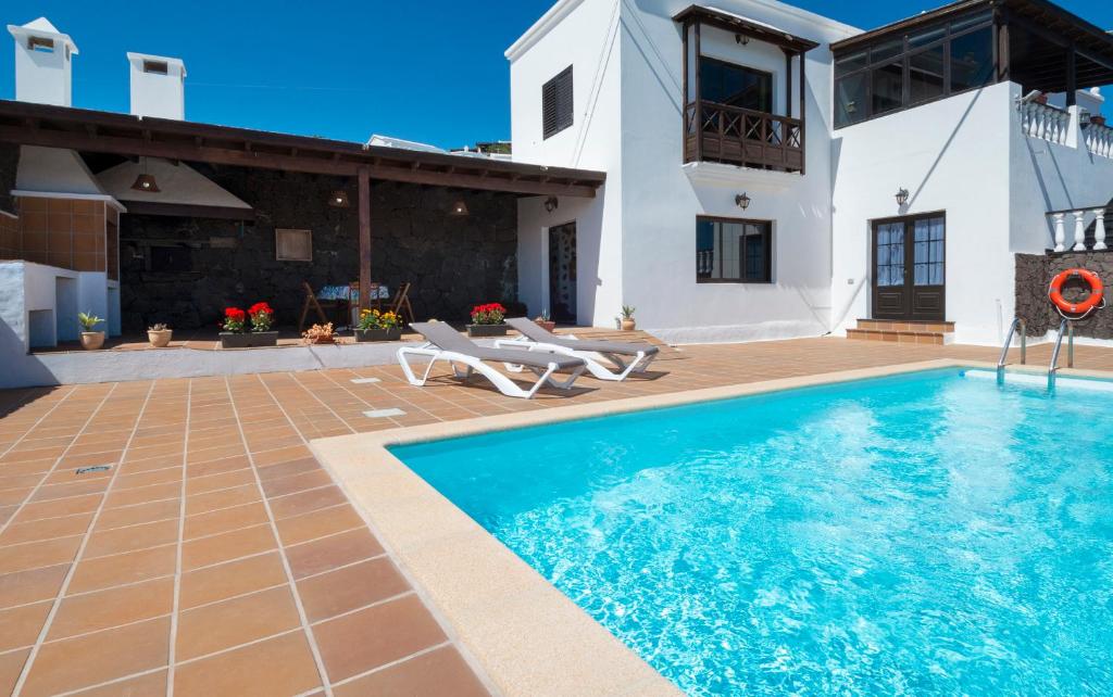 eine Villa mit einem Pool und einem Haus in der Unterkunft Apartamento Casa Belen in Conil