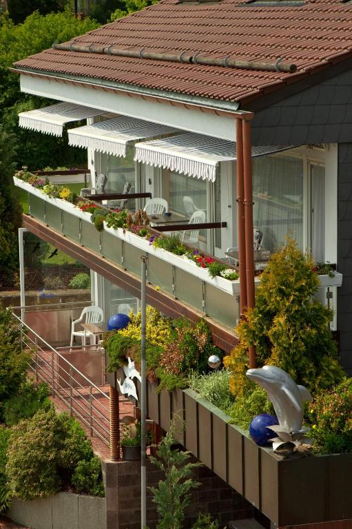 a house with a balcony with plants and flowers at Haus Delphin in Bad Wildungen