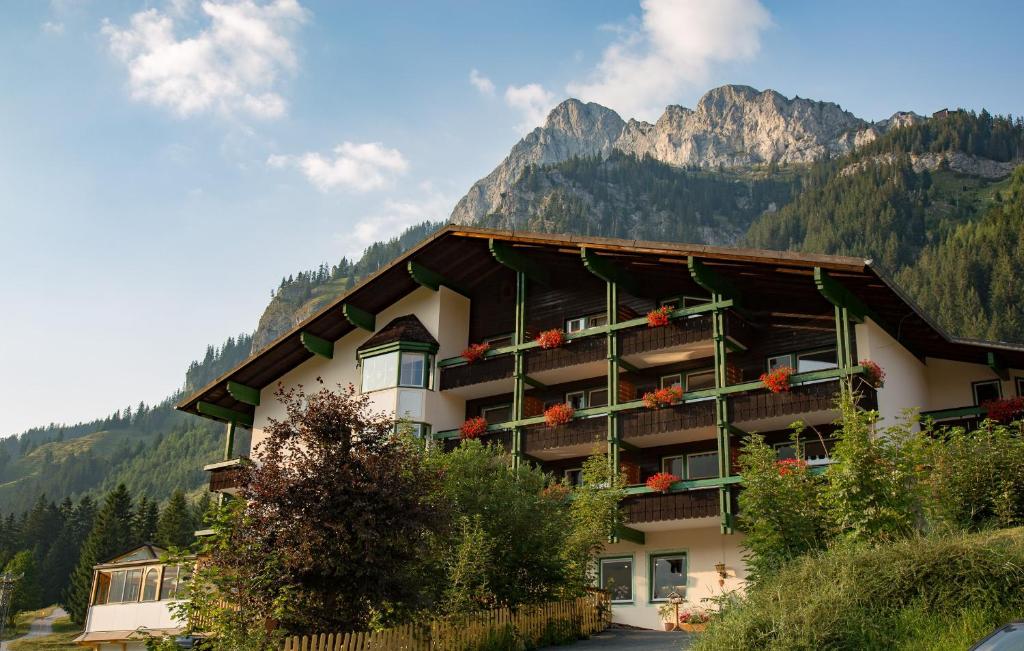 a hotel in the mountains with mountains in the background at Hotel Berghof in Nesselwängle