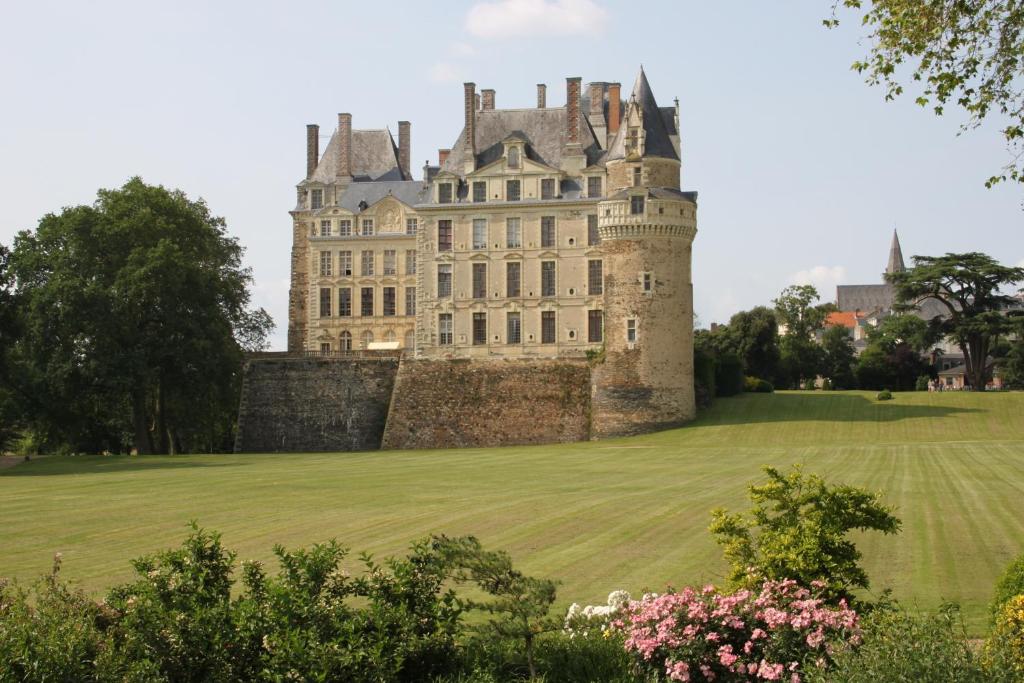 zamek z trawiastym polem przed nim w obiekcie Château de Brissac w mieście Brissac-Quincé