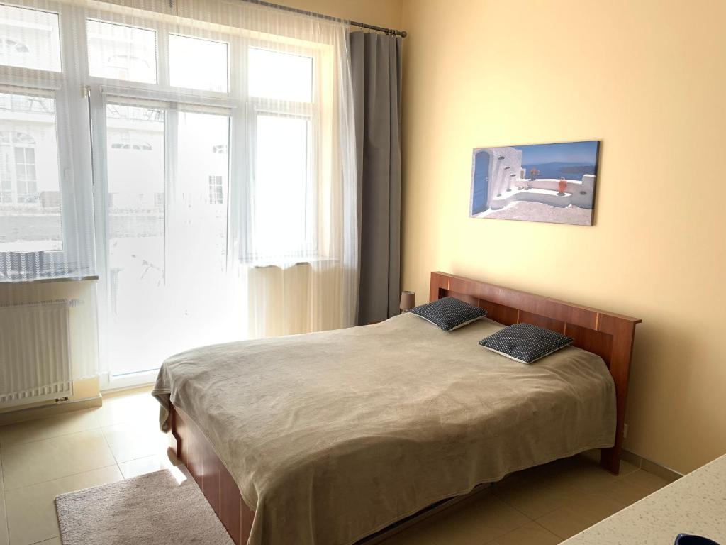 a bed in a room with a large window at Apartamenty Trzy Korony in Świnoujście