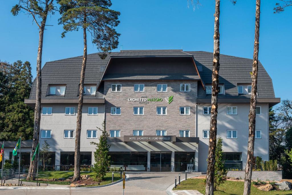 un hôtel avec des palmiers devant lui dans l'établissement Hotel Laghetto Fratello, à Gramado