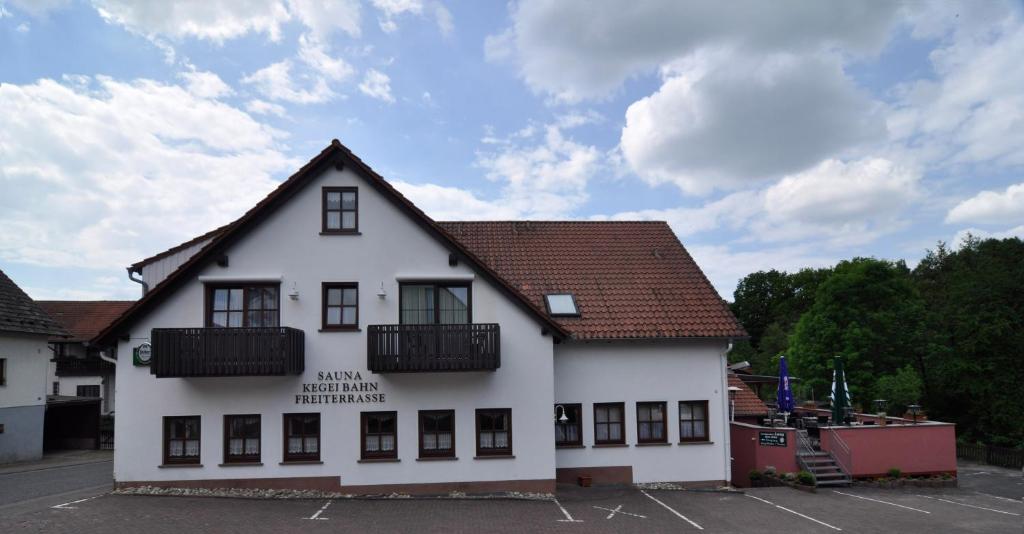 een wit gebouw met een bruin dak bij Landgasthof Lang Zum Adler in Oberkalbach