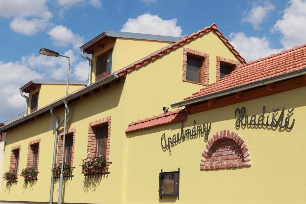 ein gelbes Gebäude mit Blumen auf der Seite in der Unterkunft Apartmány Hradiště in Znojmo