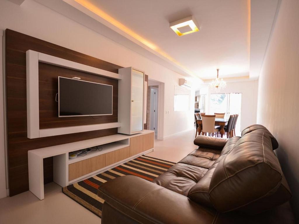 邦比尼亞斯的住宿－1034 - Apartamento para locação em Bombinhas，带沙发和平面电视的客厅