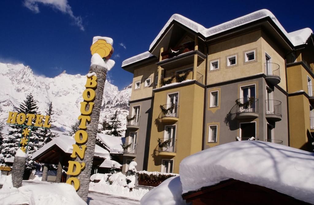 a large building with a snowboard on top of it at Hotel Bouton d'Or - Courmayeur in Courmayeur