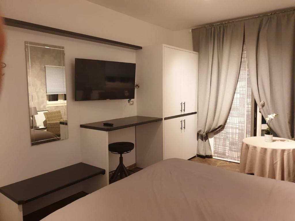 een slaapkamer met een bed, een bureau en een televisie bij Residenza Carlucci in Angri