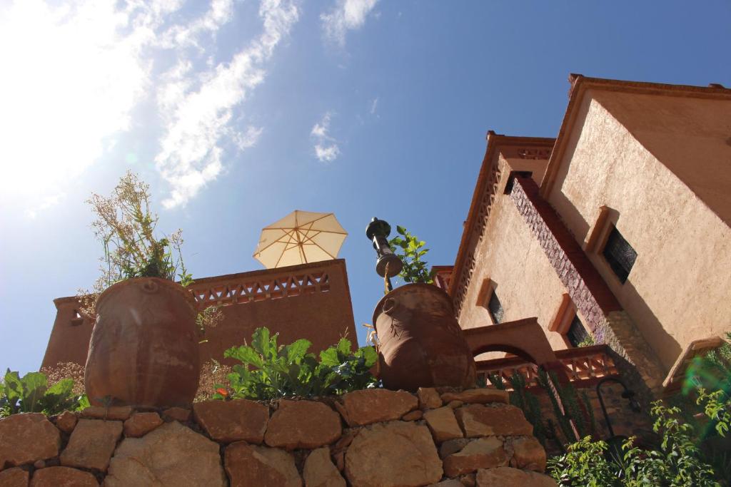 dos jarrones grandes sentados en la parte superior de una pared de piedra en Riad Gabsi Dades, en Boumalne