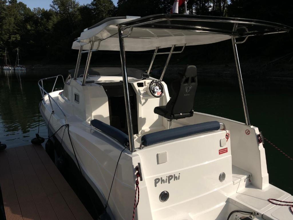 a white boat tied to a dock in the water at EKO-YACHT in Polańczyk