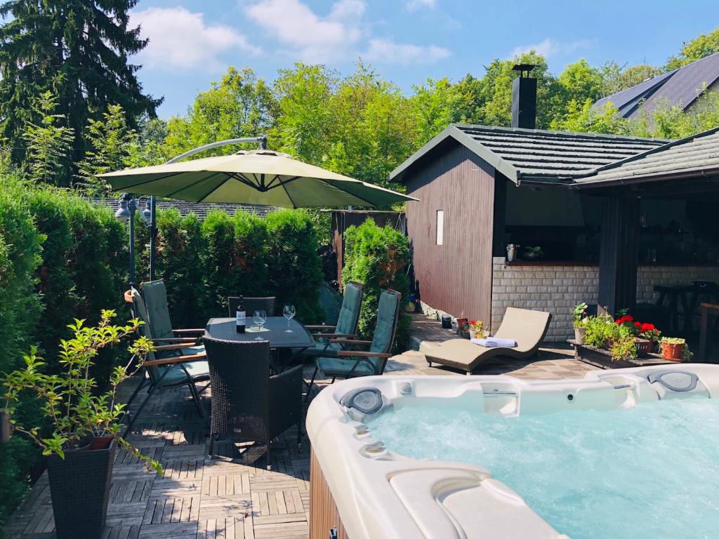 a backyard with a hot tub and an umbrella at Villa Mukinja in Plitvička Jezera