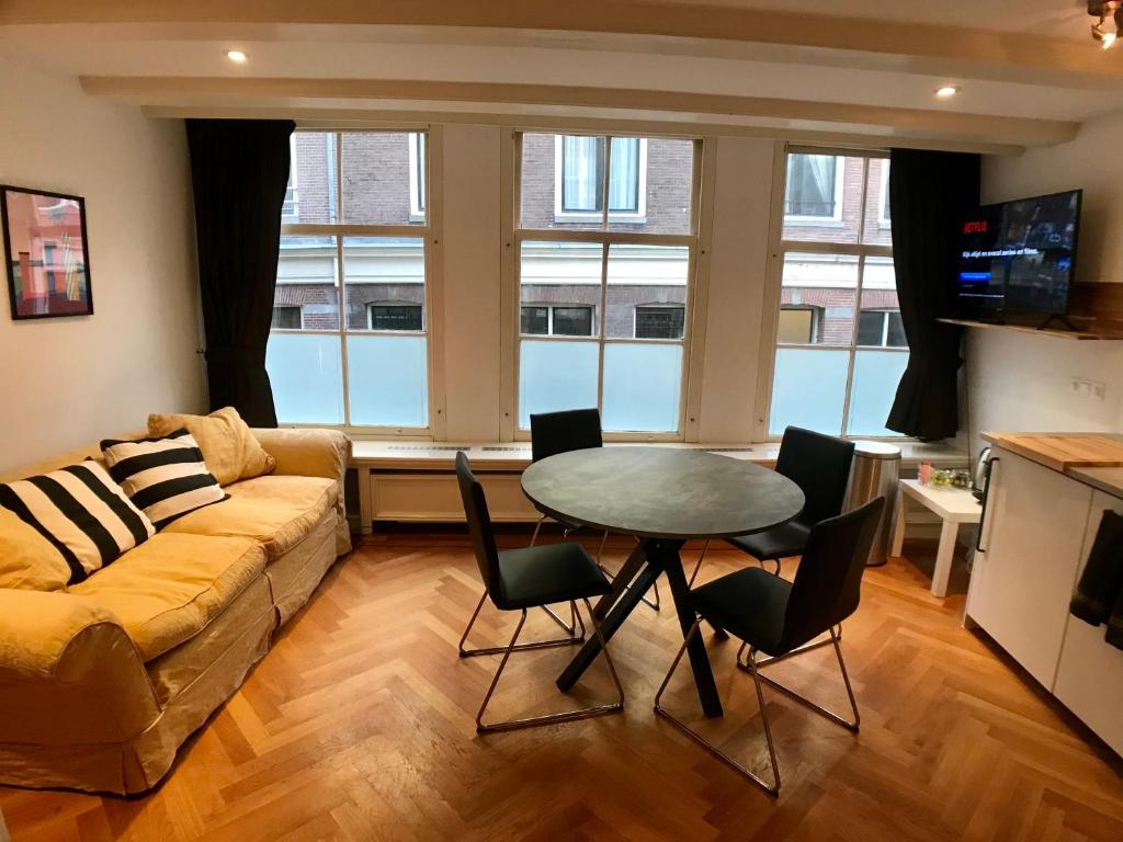 a living room with a couch and a table and chairs at Heerengracht Penthouse Apartment in Amsterdam